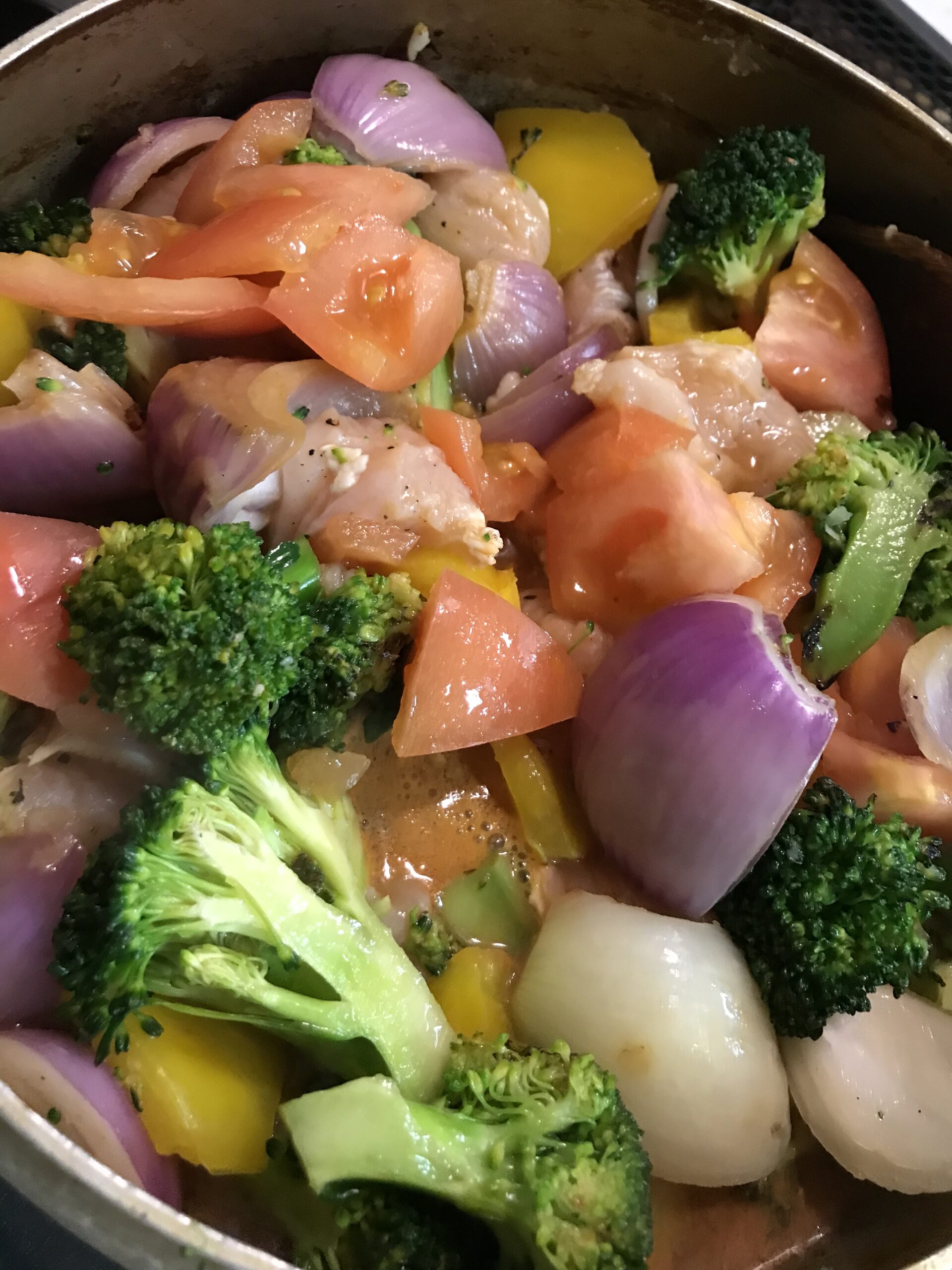 材料の紫玉ねぎなどの野菜、鶏肉、豆を煮込む途中の様子を撮影した写真
