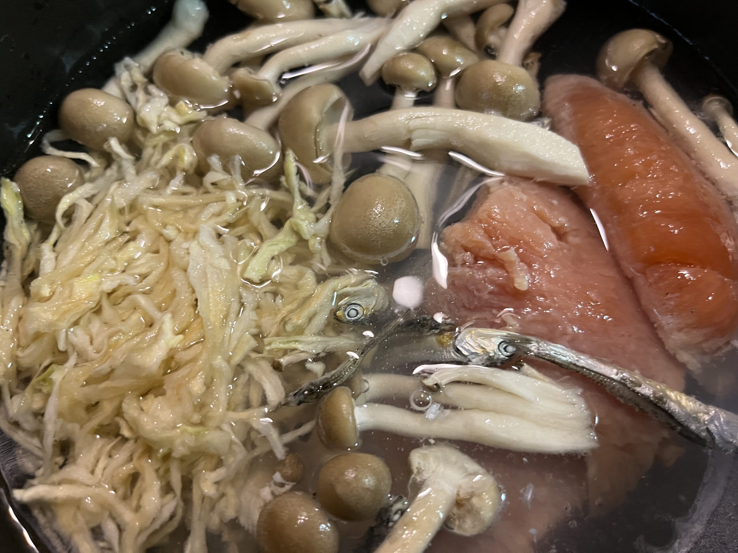 秋鮭、切り干し大根、しめじを鍋に入れて煮ている様子を撮影した写真