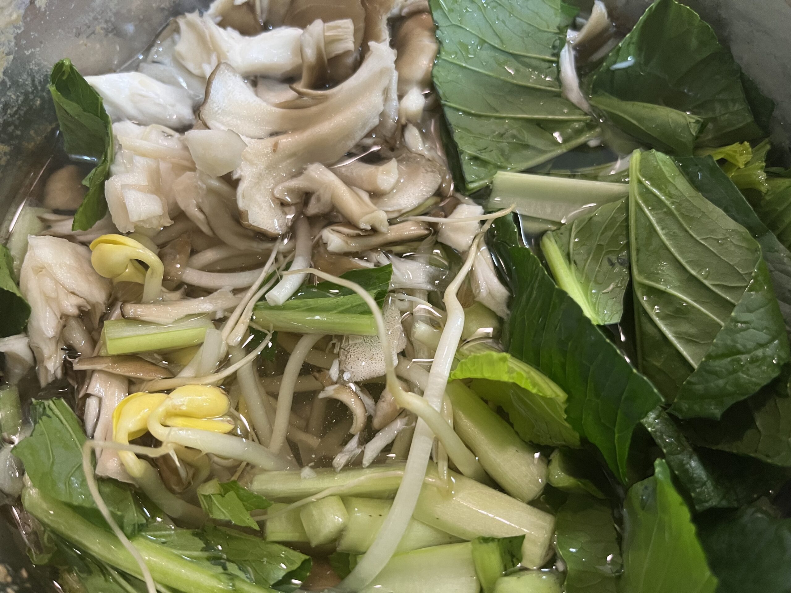 豆もやし、舞茸、小松菜を入れて煮立たせる様子を撮影した写真